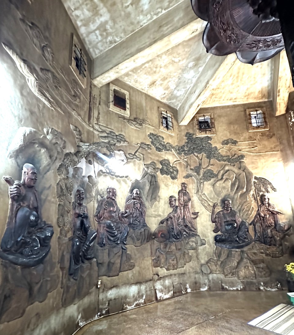 Trên tường bao điện thờ Phật Tổ dưới Ông Phật Trắng là một bức tranh điêu khắc rất nhiều vị La Hán