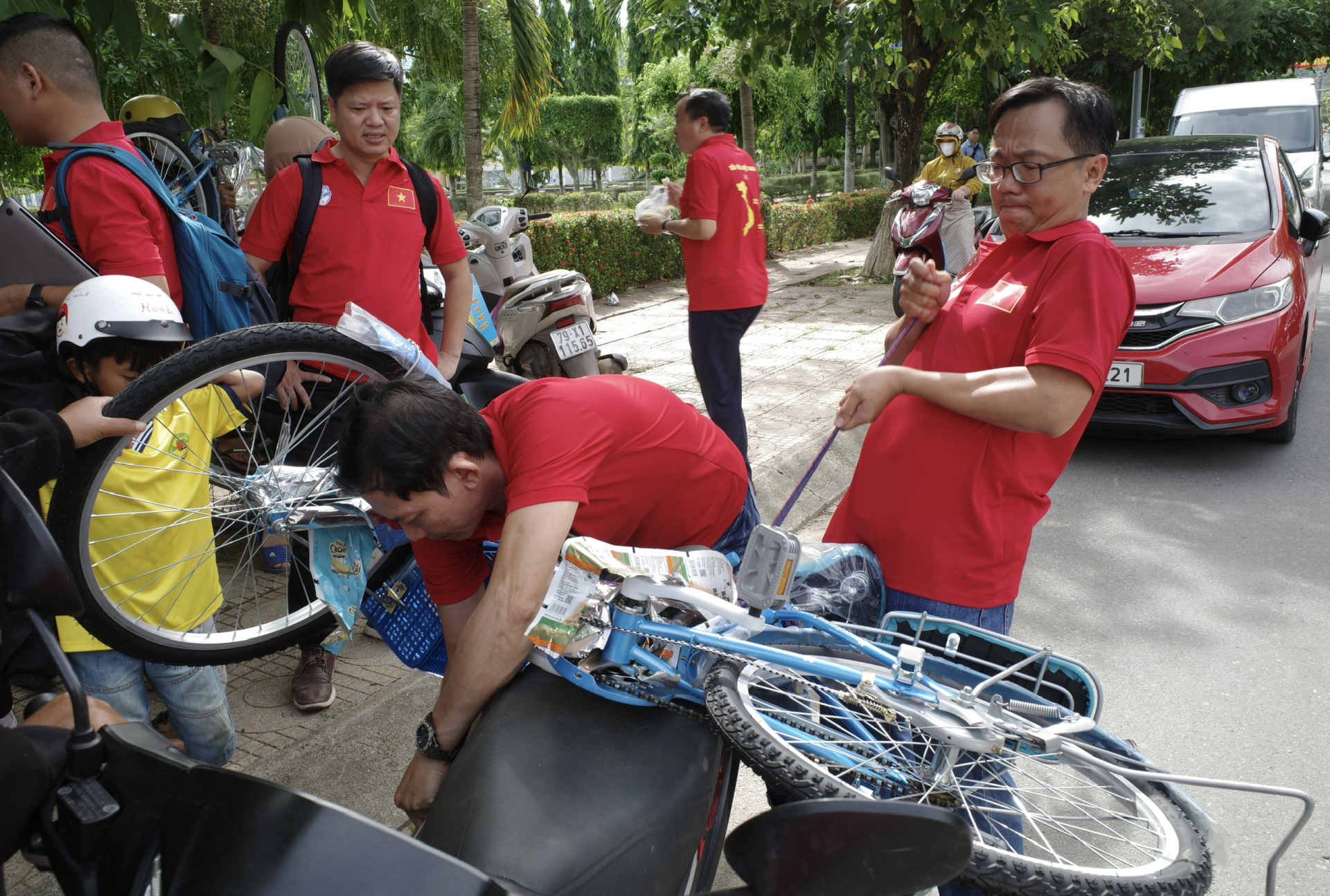 Các nhà báo phụ cột quà xe đạp của các cháu lên xe máy của phụ huynh 