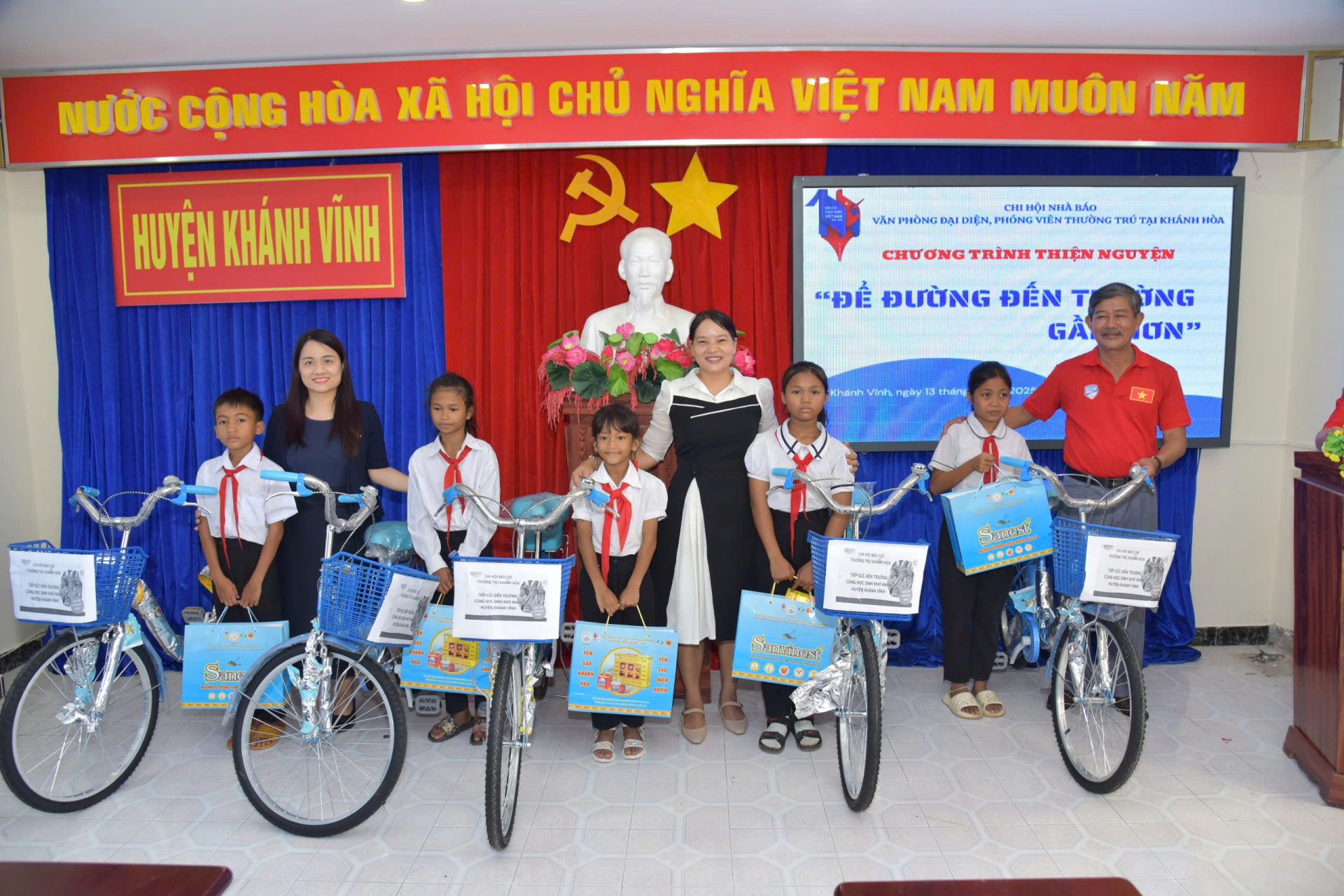 Phó Chủ tịch UBND huyện Khánh Vĩnh (giữa), Nhà báo Phong Nguyên (phải) và bà Tôn Nữ Ngọc Châu đại diện nhà tài trợ (Công ty Yến sào Khánh Hòa) trao quà cho các học sinh giỏi, xuất sắc người đông bào Raglai
