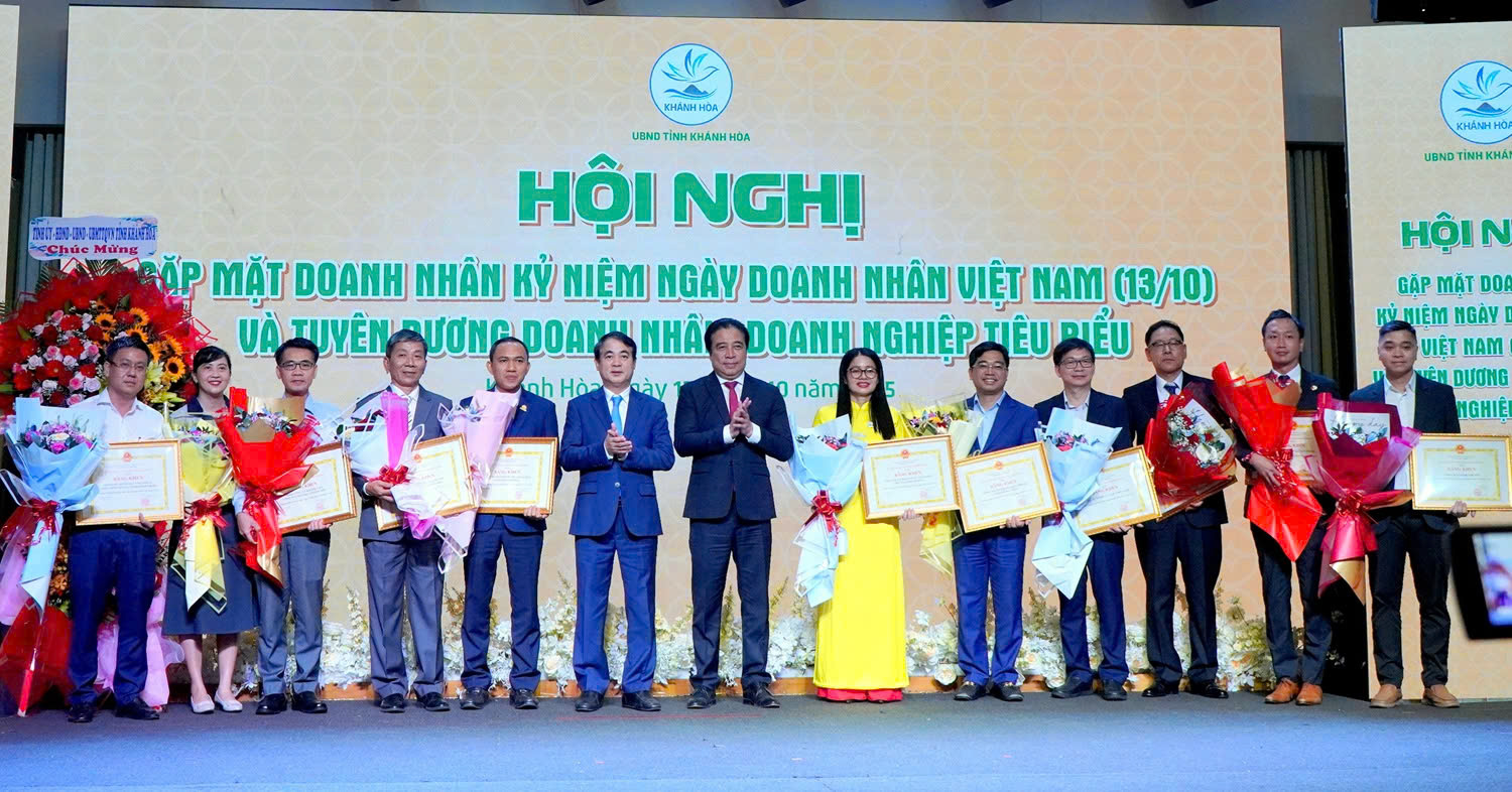 Ông Nghiêm Xuân Thành, Bí thư Tỉnh Ủy (giữa trái) và ông Nguyễn Khắc Toàn, Chủ tịch UBND tỉnh (giữa phải) trao bằng khen và hoa tôn vinh 21 doanh nghiệp tiêu biểu của tỉnh Khánh Hòa