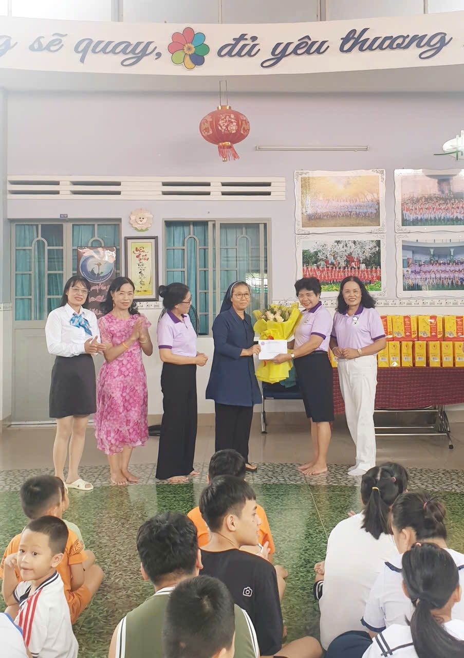 NGƯT.PGS.TS.Nguyễn Thị Thúy Hường- Chi hội trưởng Chi hội Nữ Trí thức tỉnh Khánh Hoà trao tặng hoa và quà cho Soeur Phụ trách Trường
