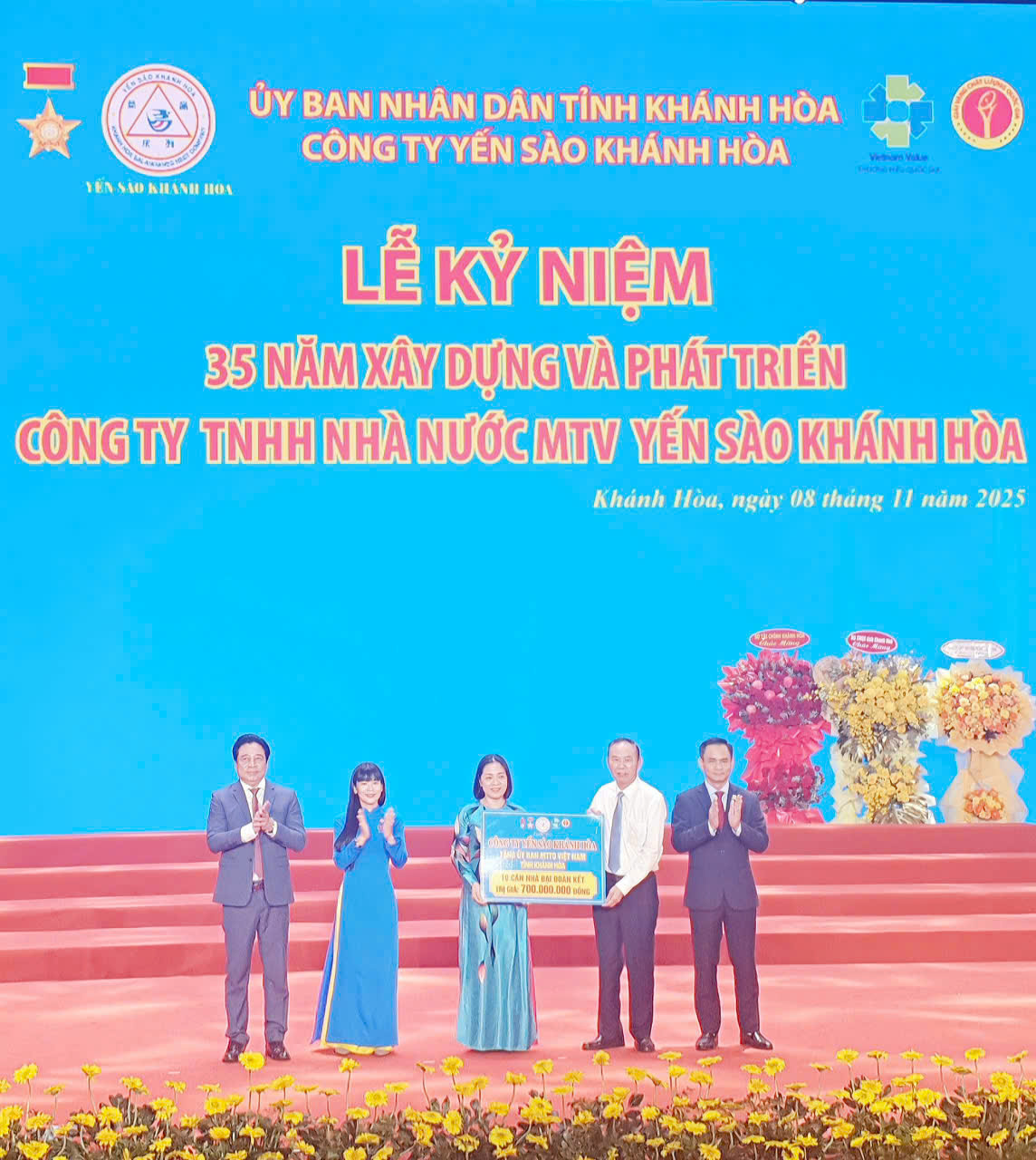 Ông Phùng Đức Tiến, Thứ trưởng Bộ Nông nghiệp và Môi trường (áo trắng) cùng Chủ tịch tỉnh Khánh Hòa và lãnh đạo Công ty trao tặng biểu trưng nhà tình nghĩa cho bà Thu Mai, Phó Chủ tịch UBMTTQ Việt Nam tỉnh Khánh Hòa đại diện nhận.