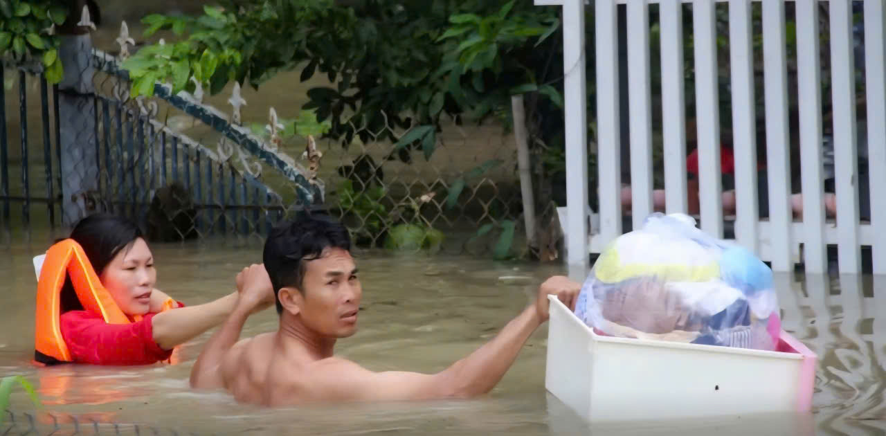 Đôi vợ chồng dìu nhau chạy lũ ở Tây Nha Trang