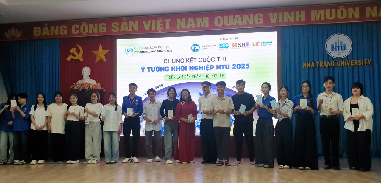 Ths.Nguyễn Thị Dung, chủ nhiệm học phần Khởi nghiệp, đổi mới, sáng tạo (áo dài đỏ, giữa) trao tặng quà động viên đại diện các nhóm sáng tạo do cô phụ trách hướng dẫn.