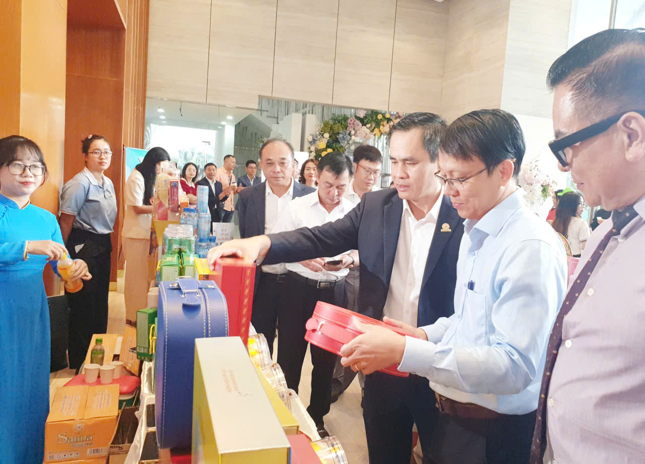 Ông Nguyễn Thanh Hải, Chủ tịch Hội Doanh Nhân Trẻ Khánh Hòa (áo vét đen) giới thiệu sản phẩm quà tặng Tết của Công Ty Yến sào Khánh Hòa với ông Nguyễn Thanh Hà, Phó Chủ tịch UBND tỉnh Khán Hòa (áo sơ mi xanh nhạt)