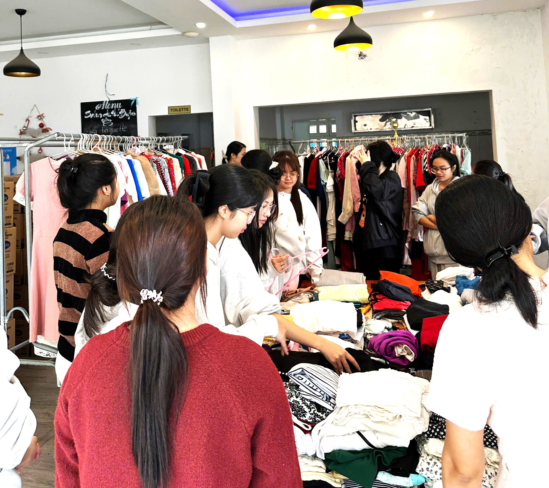 Các bạn nữ sinh viên NTU đang sắp xếp trưng bày quần áo chuẩn bị đón người nhận