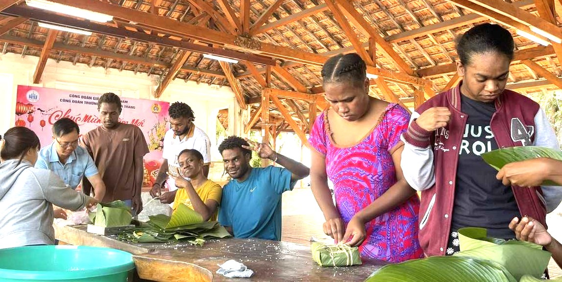 Các bạn sinh viên quốc tế học tại NTU cùng học gói bánh chưng với thầy cô để đón Tết Việt