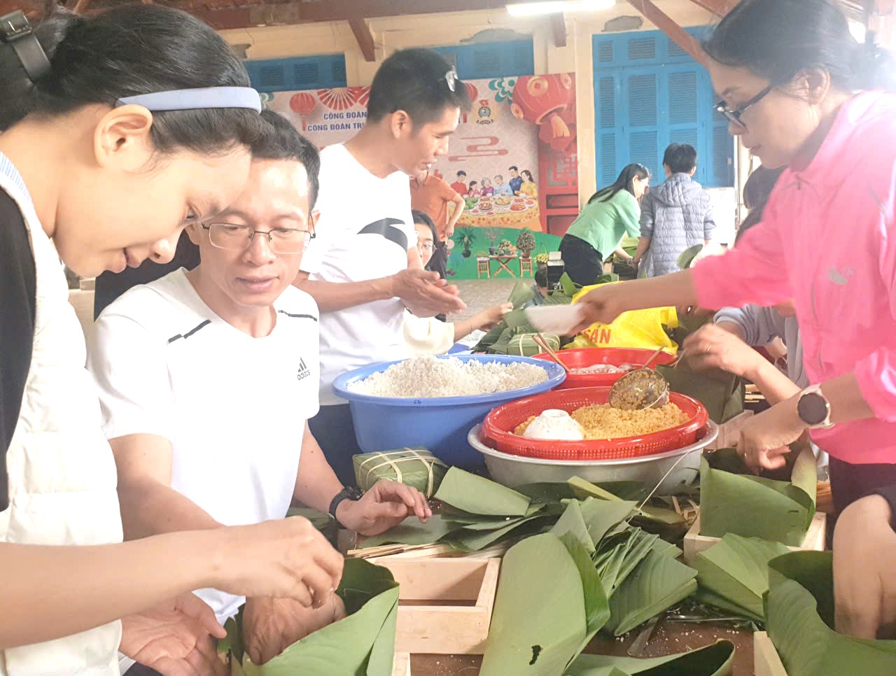 Vợ chồng, bố con, các gia đình nhỏ của NTU đều chung tay gói bánh.