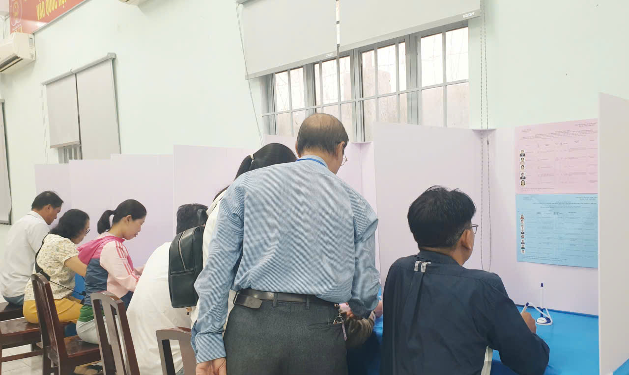 gen-n-Các thành viên tổ bầu cử hướng dẫn cử tri tận tình.