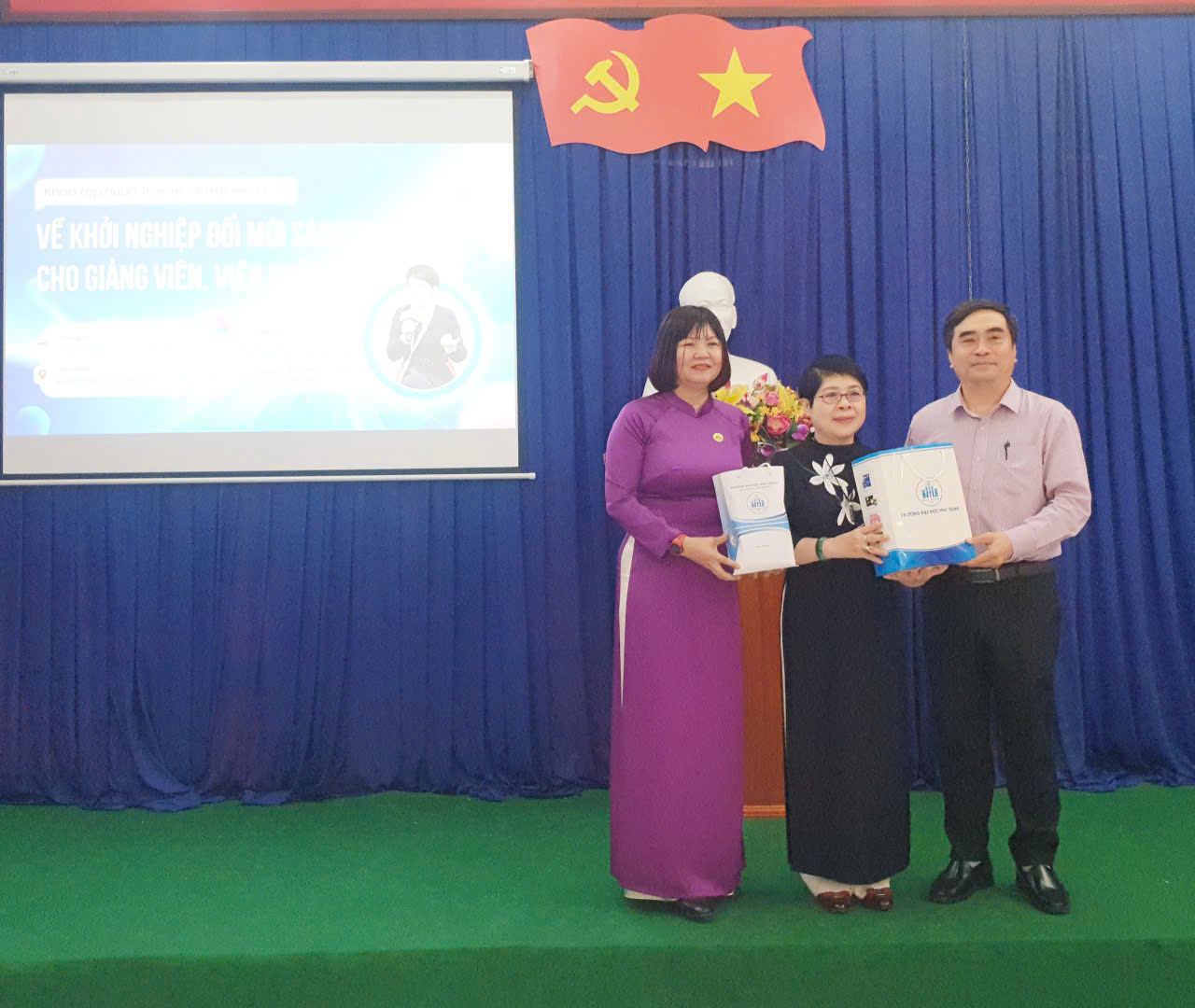 PGS.TS Phạm Quốc Hùng- Phó Hiệu Trưởng NTU và TS.Trần Thị Mỹ Hạnh (áo dài tím) tặng quà tri ân cho diễn giả, TS. Đặng Mỹ Châu