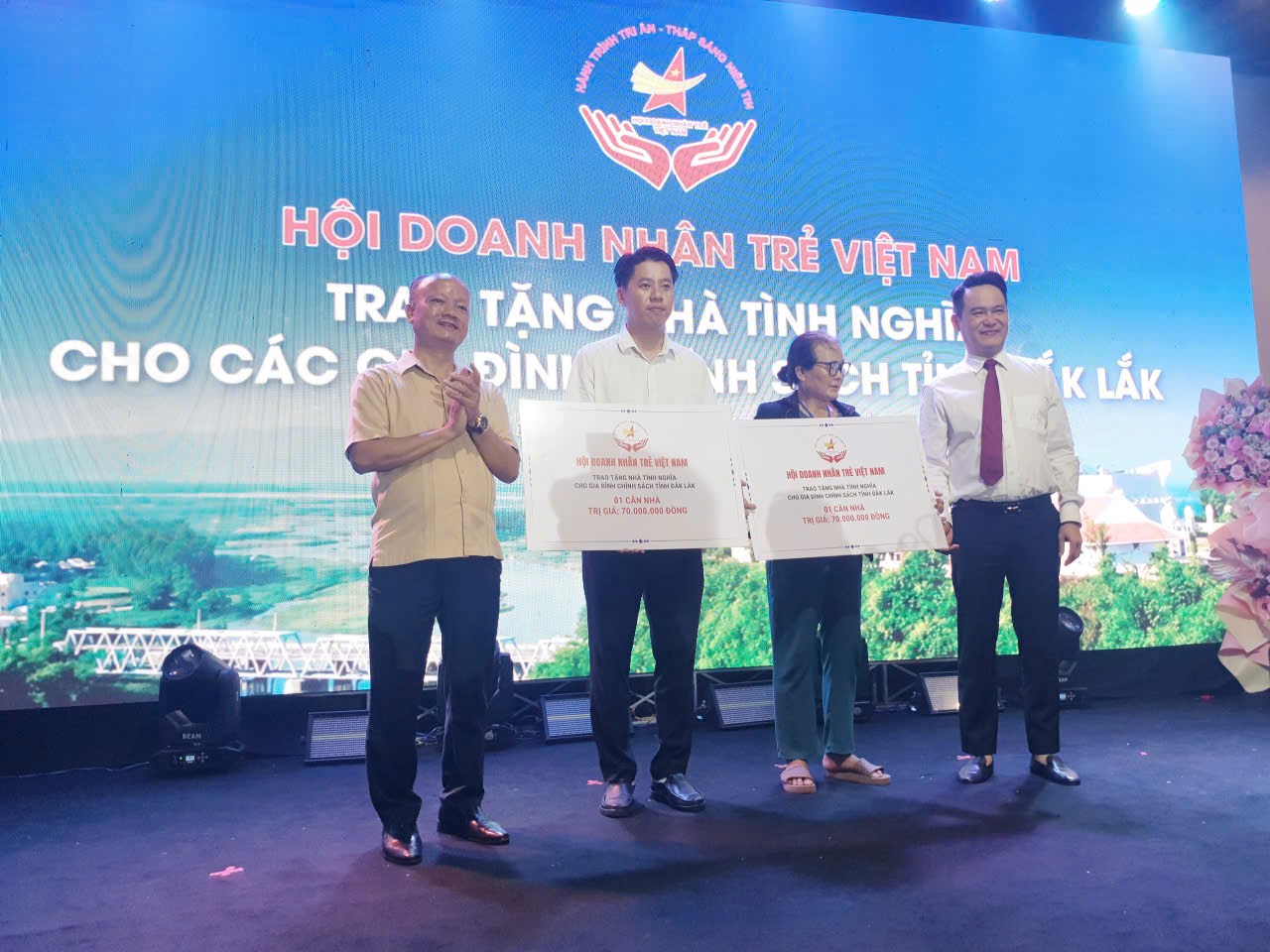 Chủ tịch Hội Doanh Nhân trẻ Việt Nam (phải) và phó Chủ tịch (trái) trao biểu trưng tặng 2 nhà tình nghĩa cho người dân Đắk Lawsk, mỗi căn trị giá 70 triệu đồng