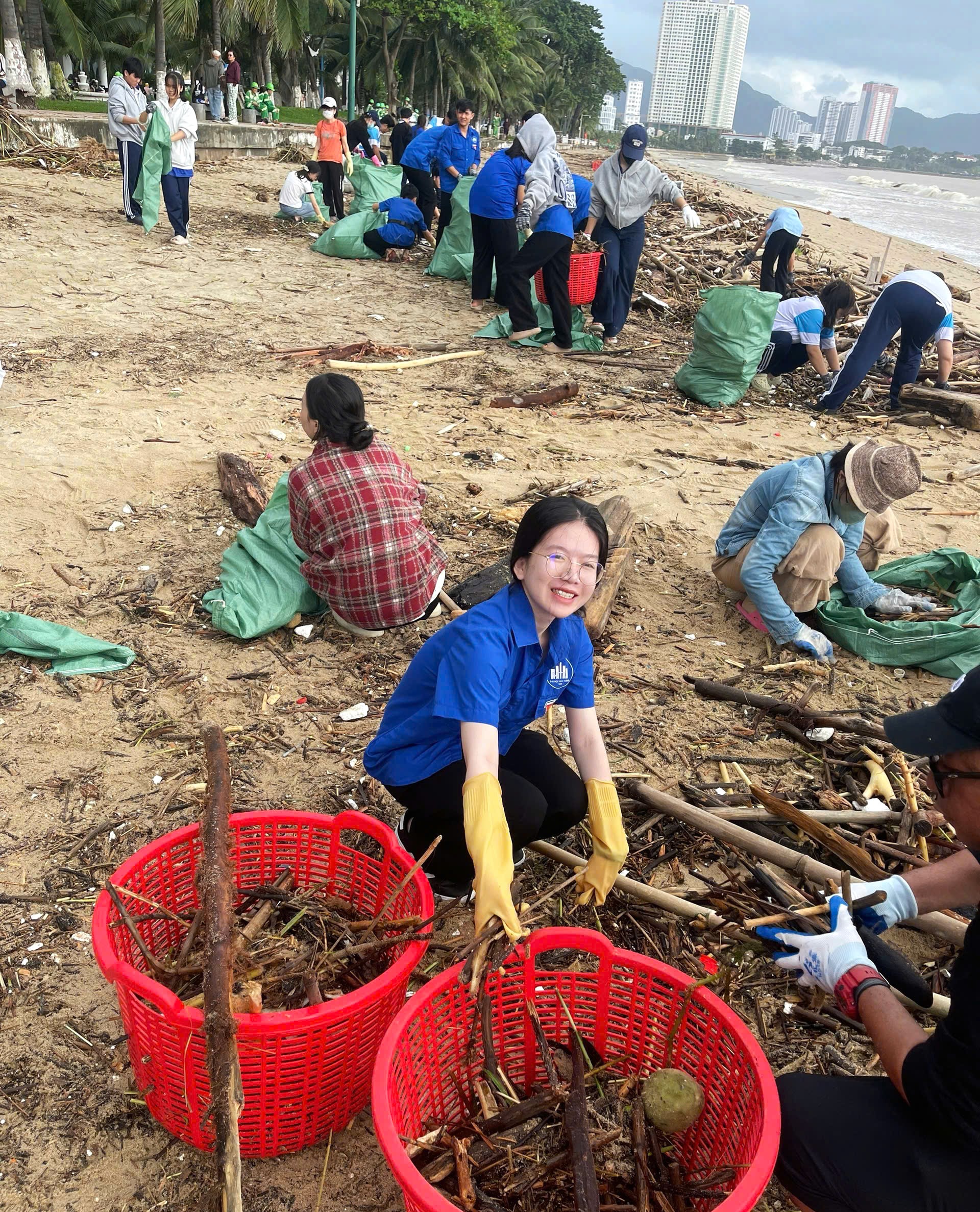 Nguyệt Minh cùng hoạt động của Đoàn thanh niên NTU nhặt rác bên bờ biển sau những ngày mưa bão