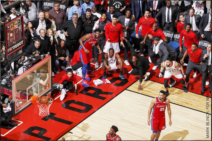   Người ngồi xổm ở trung tâm bức ảnh của Mark Blinch là Kawhi Leonard của đội bóng rổ Toronto Raptors (Canada) tại bán kết NBA Playoffs 2019. Toronto Raptors tiếp tục là đội đầu tiên có trụ sở bên ngoài Hoa Kỳ giành chiến thắng trong trận chung kết NBA. Bức ảnh chiến thắng hạng mục “Khoảnh khắc thể thao”.  