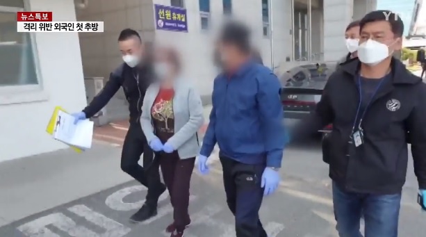 Hai vợ chồng người Việt Nam (giữa) vi phạm quy định cách ly ở Hàn Quốc. Ảnh cắt từ clip.