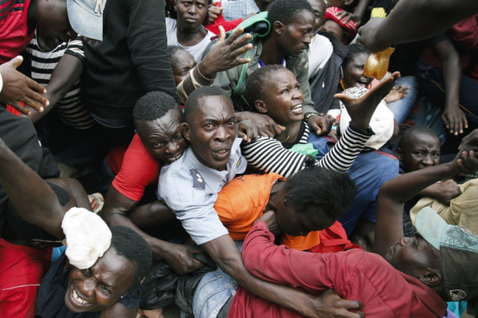 Nhiều người dân khu ổ chuột Kibera ở Kenya bị thương vì trúng hơi cay khi tranh cướp thực phẩm do các nhà hảo tâm cứu trợ - Ảnh: AP