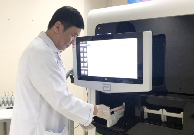   Tiến sĩ, bác sĩ Trương Thiên Phú, Trưởng khoa Vi sinh, Bệnh viện Chợ Rẫy, thực hành trên hệ thống xét nghiệm chẩn đoán bằng sinh học phân tử.  
