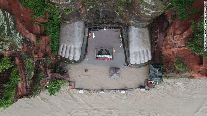 Đây là lần đầu tiên kể từ năm 1949, nước lũ chạm đến ngón chân của tượng Phật. Ảnh: China News.