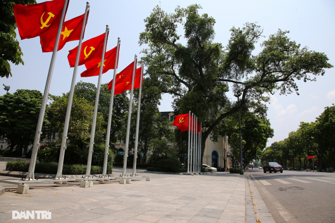   Dưới tượng đài vua Lý Thái Tổ bên hồ Hoàn Kiếm, cờ Đảng và cờ Tổ quốc tung bay.  