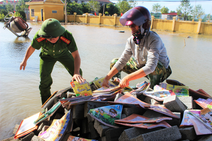 Lực lượng công an hỗ trợ phơi sách vở cho các em học sinh.