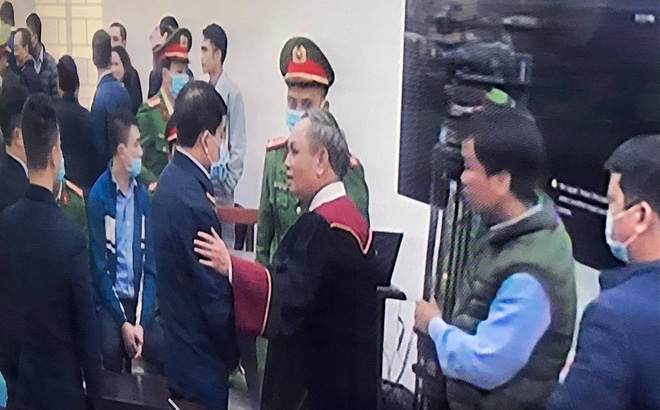   Thẩm phán Trương Việt Toàn vỗ vai ông Nguyễn Đức Chung sau phiên xử. Ảnh chụp qua màn hình.  