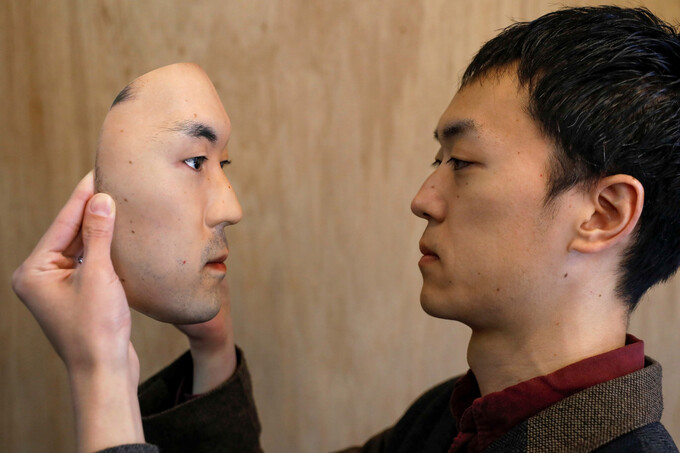   Shuhei Okawara và mặt nạ mô phỏng chính gương mặt của anh. Ảnh: Reuters.  