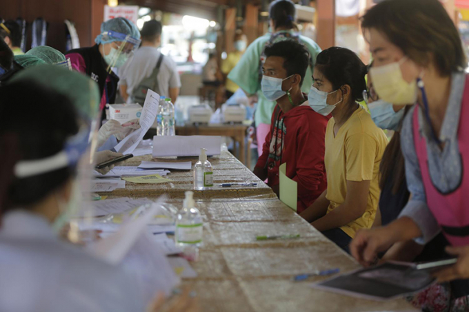   Các nhân viên y tế đang kiểm tra các lao động nhập cư tại một khu chợ ở thủ đô Bangkok.   