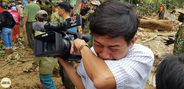 Phóng viên của Thông tấn xã Việt Nam quay máy đi chỗ khác, nghẹn khóc khi một em bé được đưa ra từ bùn đất trong vụ sạt lở ở Trà Leng (Quảng Nam). (Ảnh: Hoàng Thế Lực/Trang Thông tin Chính phủ)