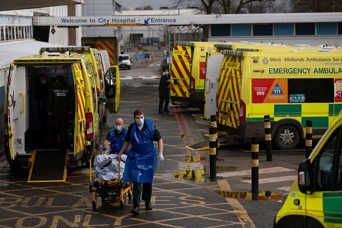   Nhân viên cấp cứu vận chuyển người mắc Covid-19 đến Bệnh viện Thành phố Birmingham, Anh, ngày 12/1. Ảnh: AP  