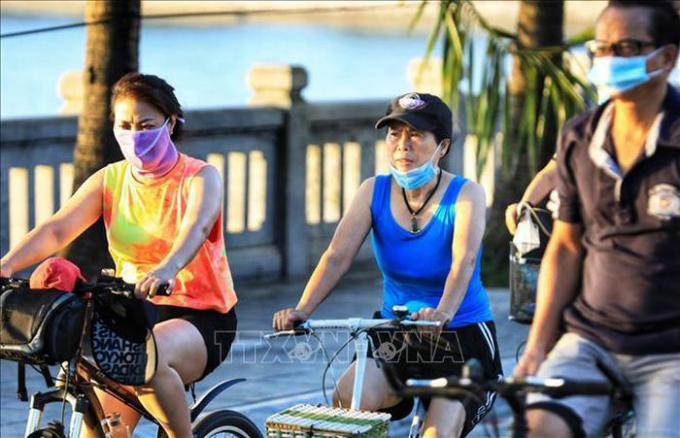   Tâm lý chủ quan người dân vẫn bỏ khẩu trang khi đi đạp xe tập thể dục tại ven đường hồ Tây.  