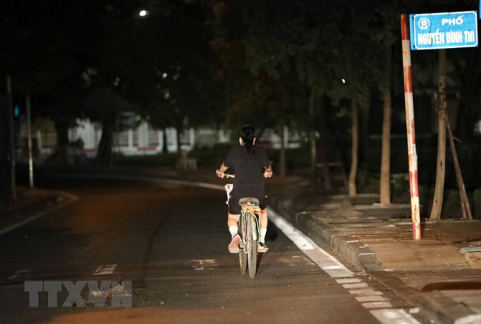 Người dân đạp xe trên đường từ sớm để tránh lực lượng chức năng (ảnh chụp lúc 4h21 phút). (Ảnh: Thanh Tùng/TTXVN)