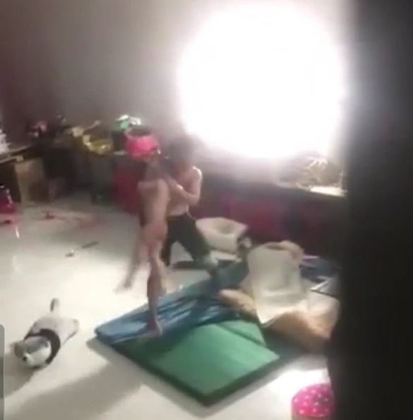   Người đàn ông nâng em bé lên rồi đập xuống nệm và đánh em suốt nhiều phút - Ảnh cắt từ video  