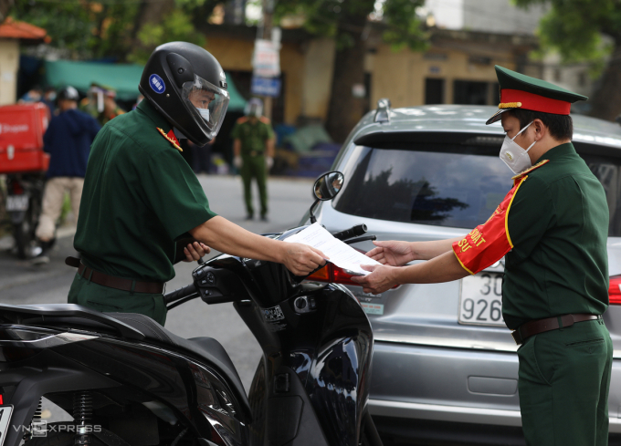  Kiểm soát quân sự kiểm tra giấy đi đường của một sĩ quan trên đường dẫn lên cầu Long Biên.  