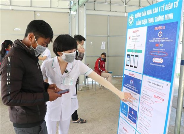 Nhân viên Bệnh viện Đa khoa tỉnh Kon Tum hỗ trợ người dân khai báo y tế và quét mã QR trên ứng dụng VietNam Health Declaration. (Ảnh: Dư Toán/TTXVN)