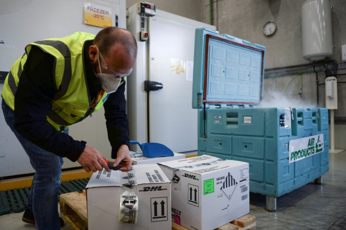 Một nhân viên đóng gói đá khô vào hộp tại sân bay quốc tế Brussels ở Bỉ để chuẩn bị vận chuyển vaccine ngừa Covid-19 vào tháng 12/2020. Ảnh: Reuters.