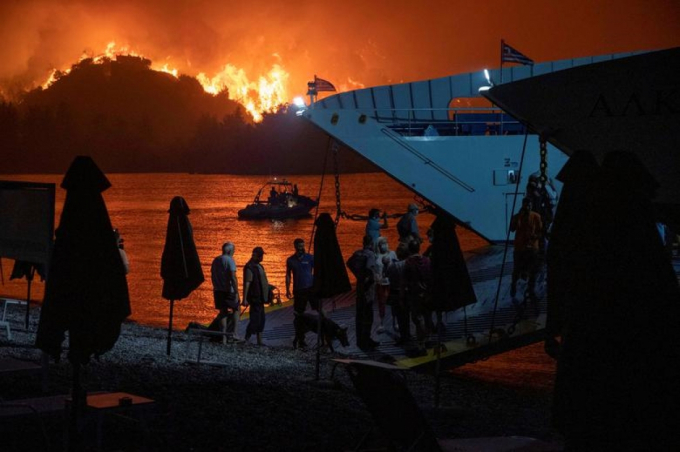 Người dân lên phà sơ tán khi đám cháy rừng lan tới làng Mimni, đảo Evia, Hy Lạp, ngày 6/8/2021.