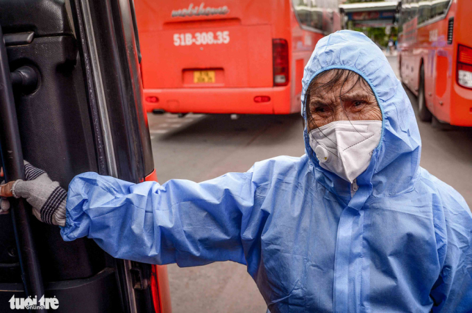   Bà Huỳnh Thị Phê - 74 tuổi, quê Phú Yên - bước đến cửa xe để lên chuyến xe 0 đồng về quê, bật khóc vì xúc động - Ảnh: QUANG ĐỊNH  