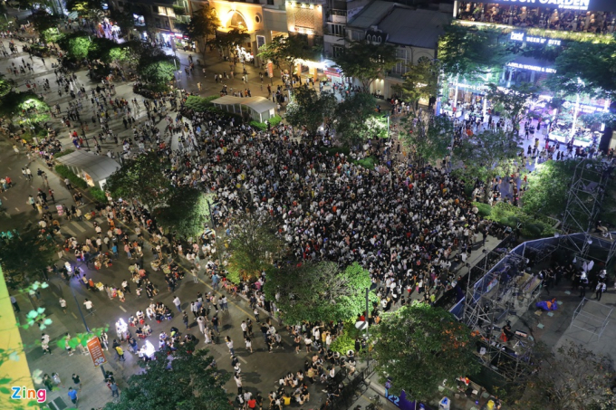           20h ngày 31/12, nhiều người dân đổ về phố đi bộ Nguyễn Huệ, tập trung tại rìa sân khấu nhạc hội. Càng cận kề thời khắc năm mới 2022, dòng người càng đông.          