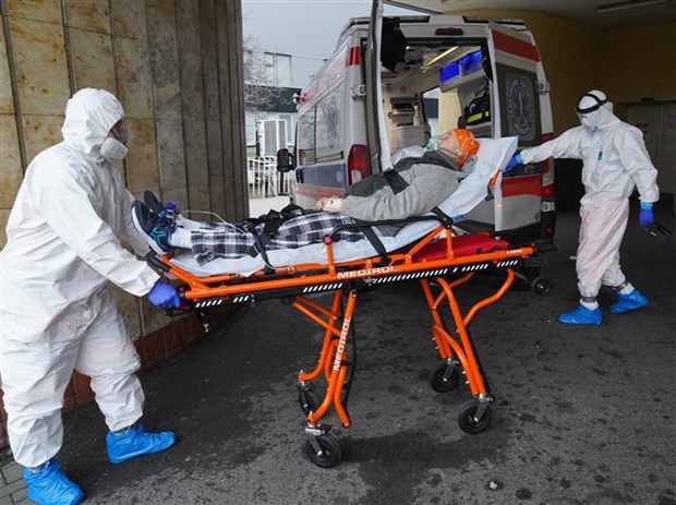  Nhân viên y tế chuyển bệnh nhân COVID-19 vào bệnh viện ở Vacsava (Ba Lan). (Ảnh: AFP/TTXVN)  