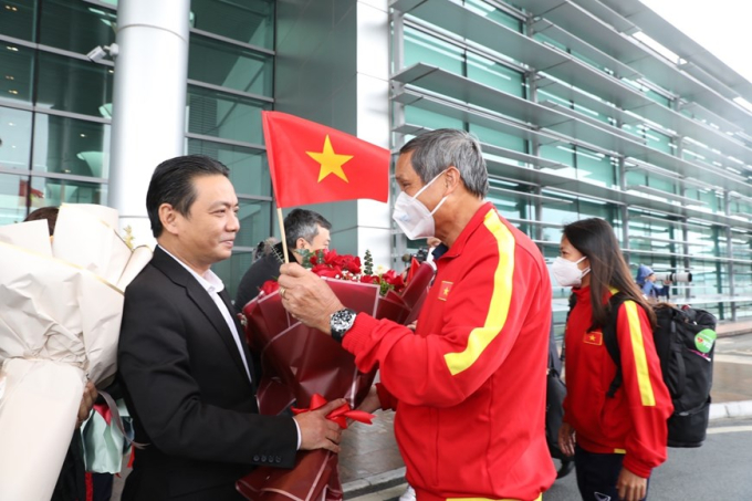 Đại diện Liên đoàn Bóng đá Việt Nam (VFF) tặng hoa chúc mừng Huấn luyện viên trưởng Mai Đức Chung tại sảnh VIP A của sân bay quốc tế Nội Bài. (Ảnh: TTXVN)