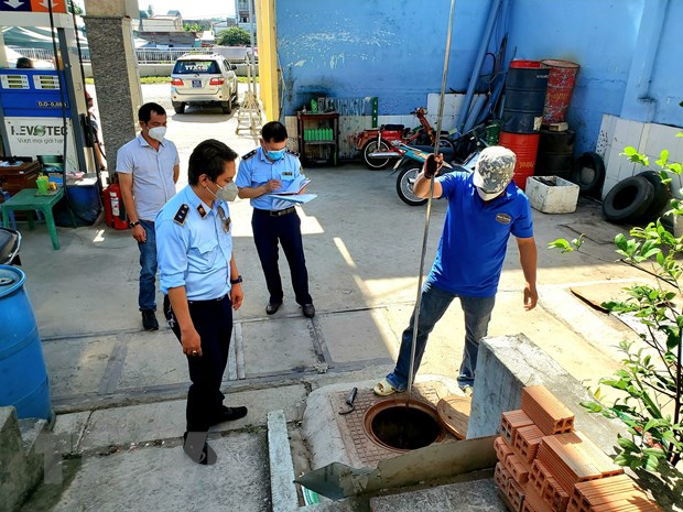   Cơ quan chức năng kiểm tra bồn chứa tại cây xăng 78/2 Bến Phú Định, quận 8. (Ảnh: Thành Chung/TTXVN)  