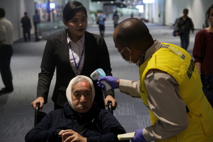   Nhân viên đo thân nhiệt cho hành khách ở sân bay quốc tế Soekarno-Hatta, Indonesia, trong bối cảnh lo ngại lây nhiễm virus đậu mùa khỉ hồi tháng 5/2019. Ảnh: AFP.  