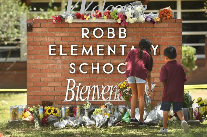 Gia đình các nạn nhân đặt hoa bên ngoài trường tiểu học Robb. (Ảnh: Wally Skalij / Los Angeles Times / TNS)