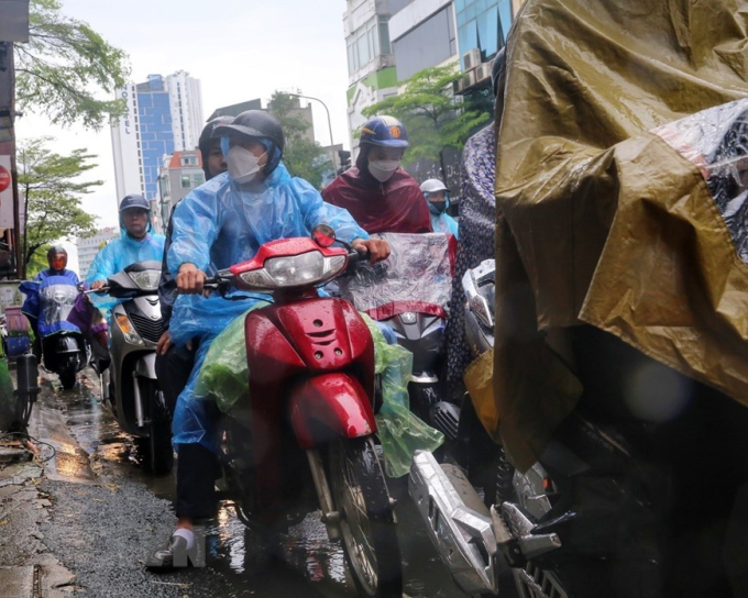 Cơn mưa to khiến người dân di chuyển khó khăn trên phố Tây Sơn sáng 6/6. (Ảnh: Tuấn Đức/TTXVN)