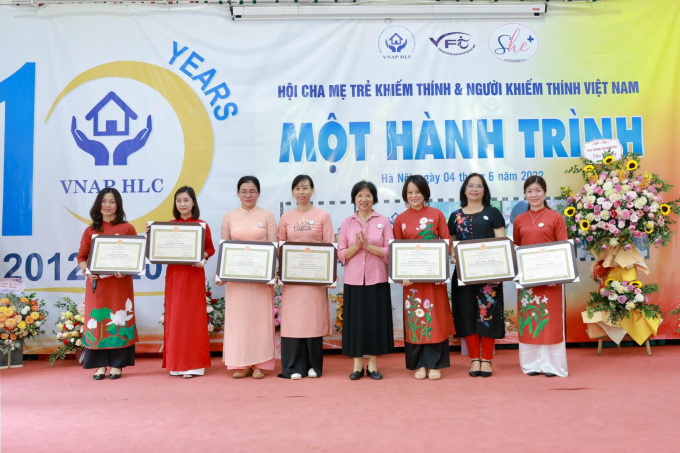 Bà Dương Thị Vân - Phó chủ tịch Liên hiệp Hội người khuyết tật Việt Nam trao tặng bằng khen cho Hội cha mẹ trẻ khiếm thính và người khiếm thính Việt Nam và 9 cá nhân.