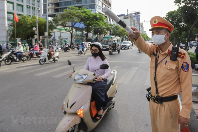 Lực lượng cảnh sát giao thông liên tục nhắc nhở và điều hướng phương tiện di chuyển theo hướng dẫn. (Ảnh: Minh Sơn/Vietnam+)