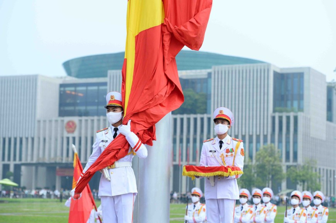 Chiến sỹ của đội hồng kỳ nghiêm trang bước lên bục để chuẩn bị thực hiện các nghi thức chính. Lúc 5h59, chiến sỹ mang Quốc kỳ treo lên cột cờ. (Ảnh: Minh Đức/TTXVN)