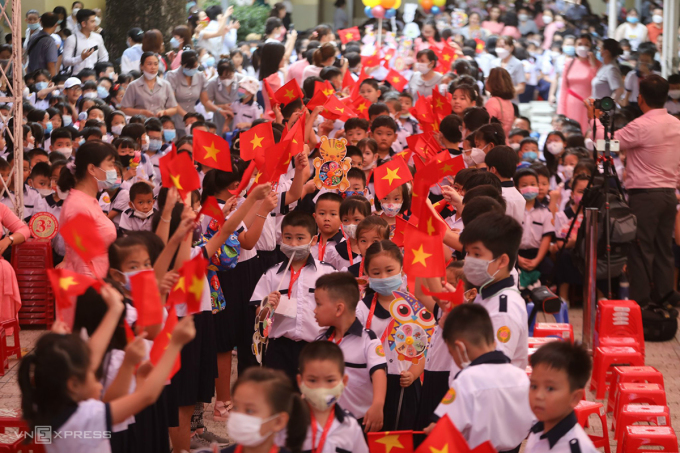   Học sinh lớp 1 trường Tiểu học Nguyễn Bỉnh Khiêm (TP HCM) được thầy cô dẫn vào lễ khai giảng trong sự chào đón của những học sinh lớp trên. Ảnh: Quỳnh Trần  