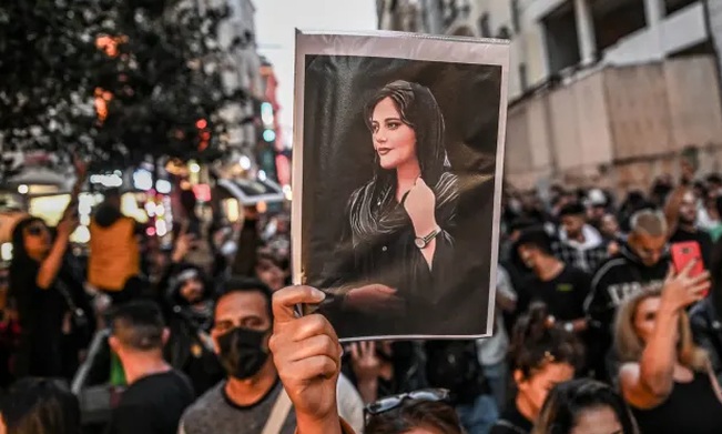   Một người biểu tình cầm ảnh chân dung của Mahsa Amini trên đại lộ Istiklal ở Istanbul (Thổ Nhĩ Kỳ). Ảnh: Getty Images  