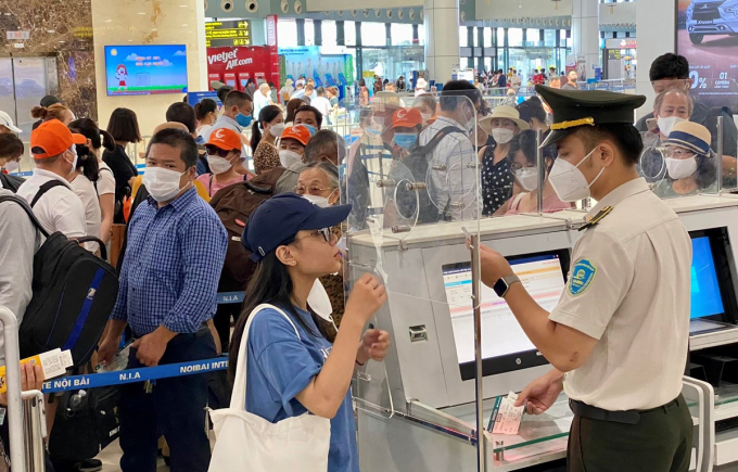 Nhân viên an ninh hàng không kiểm tra xác thực hành khách trước khi vào kiểm tra soi chiếu an ninh tại sân bay Nội Bài. (Ảnh: CTV/Vietnam+)