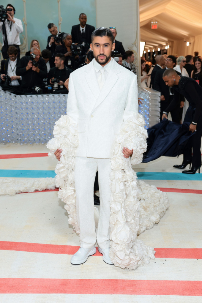   Bad Bunny là sao nam hiếm hoi lọt top mặc đẹp tại Met Gala 2023. Anh chàng diện 1 bộ suit nam khoét lưng đến từ Jacquemus, chọn áo khoác in dập vô vàn các bông hoa hồng ấn tượng.   